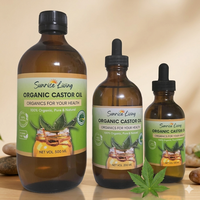 Three bottles of Sunrise Living Organic Castor Oil on a wooden surface with a beige background.