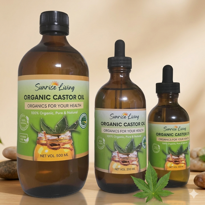 Three bottles of Sunrise Living Organic Castor Oil on a wooden surface with a beige background.