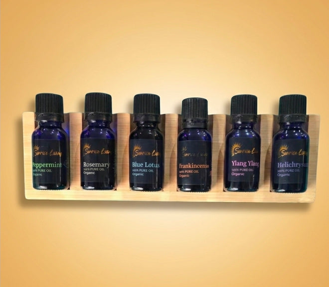 Set of six essential oil bottles on a wooden holder against a beige background